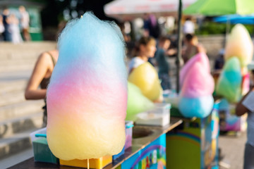 Bright big multicolored cotton candy sweet at city park during summer fair or carnival outdoors