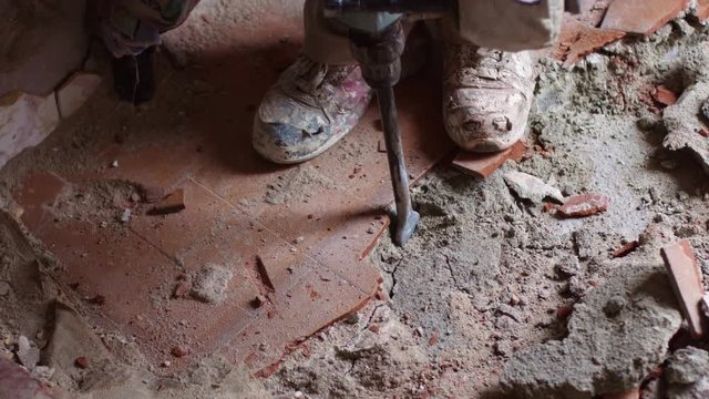 Worker in construction site remove old floor with jackhammer dril