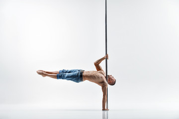 Young pole dance male athlete with white background