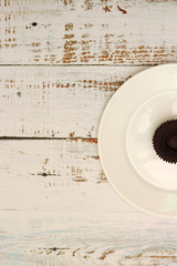 brown chocolate cupcakes with cream filling on a white plate on the table with shabby boards