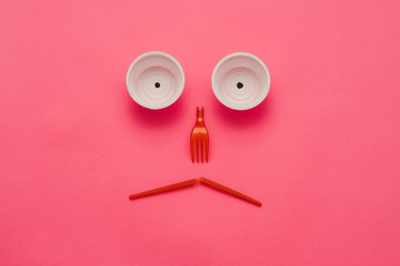 Disappointing ecological reality. Plastic garbage monster face on pink background. Zero waste lifestyle. Copy space.