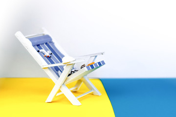 Sun lounger isolated on colourful background. Tropical vacation background. Sun lounger on the sandy island, copy space, front view