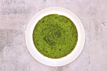 green round spinach mint cake on a white plate on a concrete background