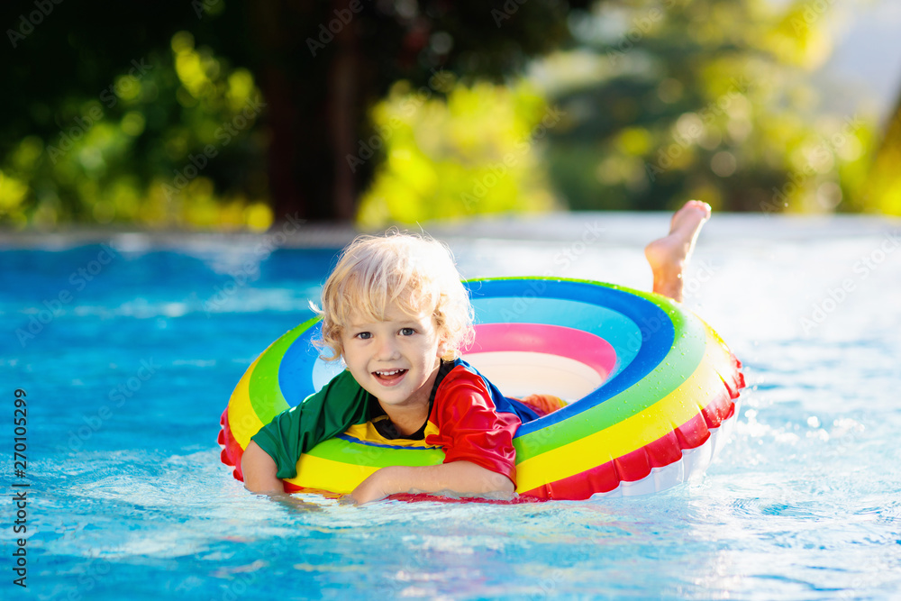 Wall mural child in swimming pool on toy ring. kids swim.