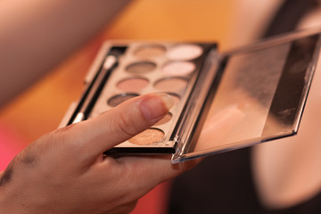 Close up of hand of artist doing wedding make up.