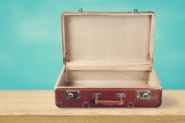 Retro suitcase with travel objects on wooden