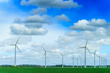 Wind power station - wind turbine against the blue sky 