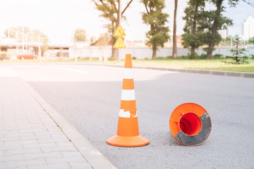 Close up of orange road cone on asphalt. Sunset