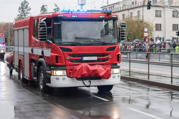 Fire brigade workers are riding fire truck on military parade