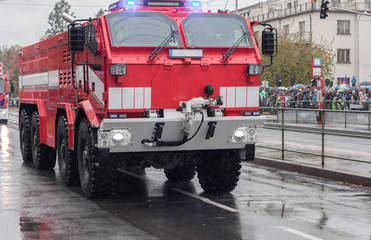 Fire brigade workers are riding fire truck on military parade