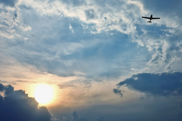 Fototapeta na wymiar light aircraft flying in the sky at sunset.. amazing nature and landscapes