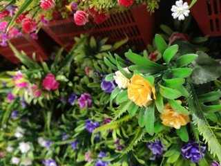  Colorful artificial flowers made of plastic display vertically in in shops for sale. 