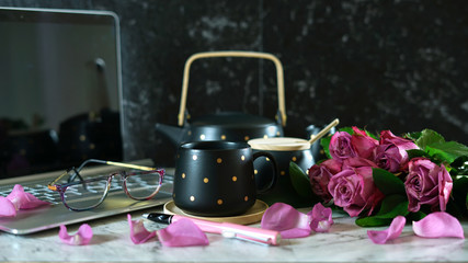 Feminine desk or workspace coffee break time with modern touch screen laptop on marble background.