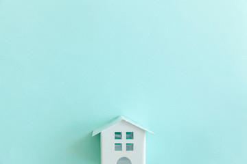 Simply design with miniature white toy house isolated on blue pastel colorful trendy background....