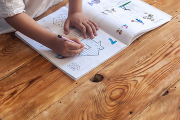 Preschool age child doing the math. Little boy doing homework. Drawing on kid notepad. Free space