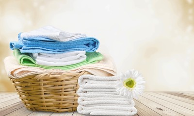 Laundry Basket with colorful towels on background
