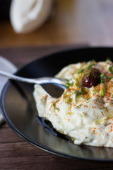 Tzatziki sauce, made of cucumber, yogurt, olive oil and garlic, served on a black plate