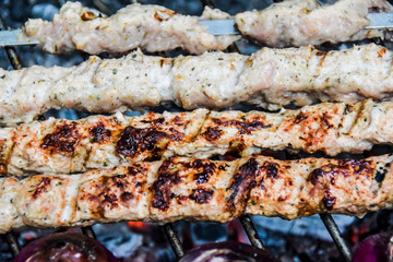 BBQ on the nature in summer meat kebab grilled over charcoal red onions on the grill