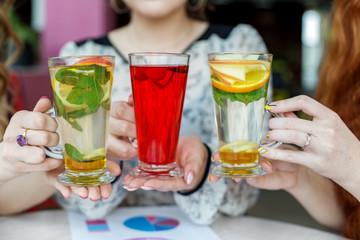 Multicolored delicious cocktails in female hands. Concept of drinks, meeting, fun and party