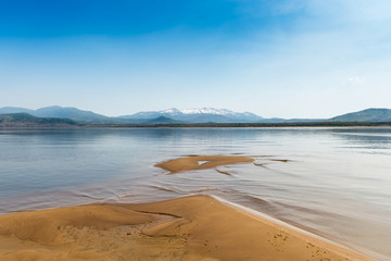 Sandy Beach on the River Amur. Khabarovsk region of the Russian Far East. Beautiful Bank of the Amur River snowy mountains and sandy beaches.