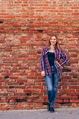 Portrait of young woman standing against brick wall © seva_blsv