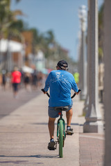 Obraz premium Image of a senior man riding a bike on Hollywood Beach FL