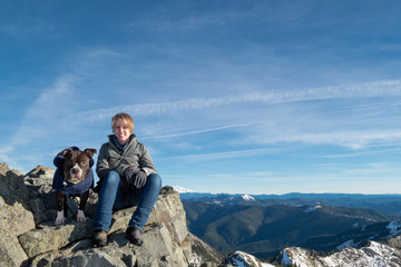 Woman Hiker Sitting on Mountain with Her Dog