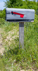 Rural mailbox on post with red flag down.
