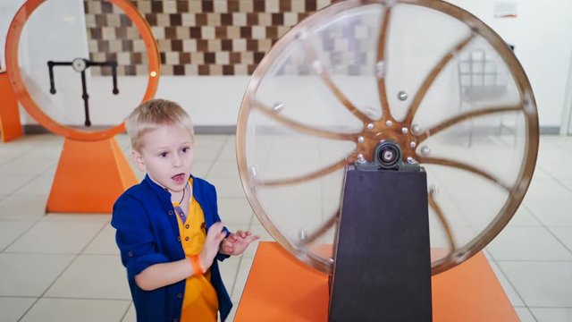 The boy examines the perpetual motion machine. Scientific Exhibition Center