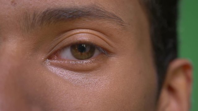 Closeup half face shoot of young attractive indian male with eyes looking straight at camera