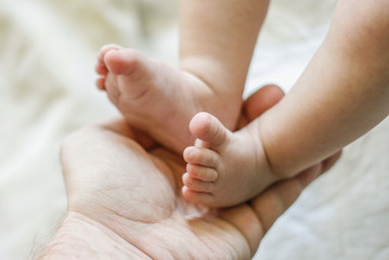 baby f&uuml;&szlig;e werden gehalten von den h&auml;nden des vaters