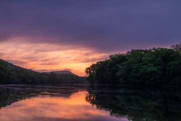 Fototapeta na wymiar Moody sunrise over Delaware Water Gap, Pennsylvania featuring lake on the foreground and mountains on the background