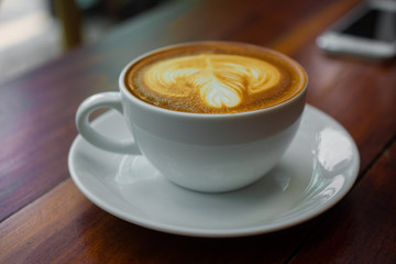 Close up Coffee Latte Art On Wooden Table in Coffee Shop