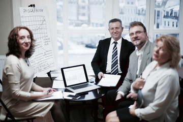 portrait of group of business people sitting near the desktop