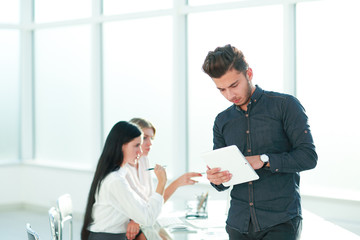 Fototapeta premium young businessman with digital tablet standing in office.