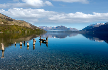 Old wooden ruined pier poles in Lake Wakatipu