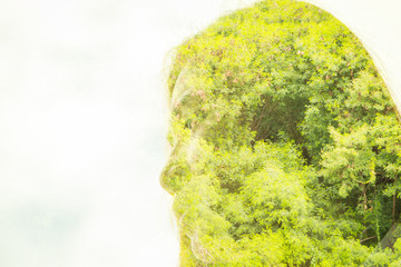 Double exposure of face woman with tree branches and leaves.