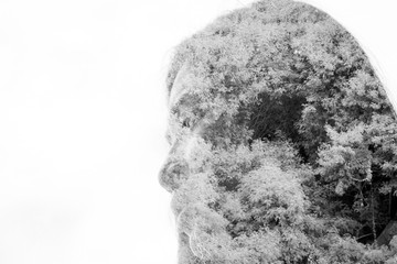 Double exposure of face woman with tree branches and leaves.