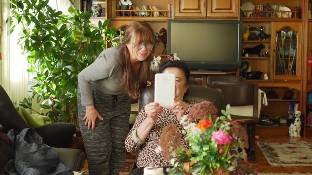 Senior woman learns how to use a digital tablet 