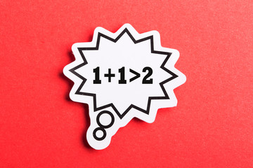 Synergy 1+1>2 Speech Bubble Isolated On Red Background