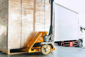 hand pallet truck or pallet jack with shipment product on pallet. truck docking load cargo in...