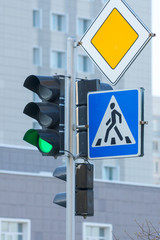 green traffic light, pedestrian crosswalk and main road traffic signs