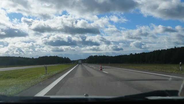 Disabled driver car windshield view driving  highway E272 or A2 in Lithuania and passing motorway roadworks