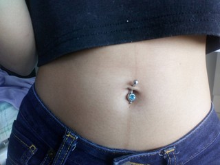 Closeup...The belly of a woman with a navel piercing.