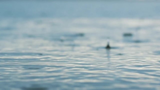 Rain on the lake, closeup of raindrops in the lake in the afternoon