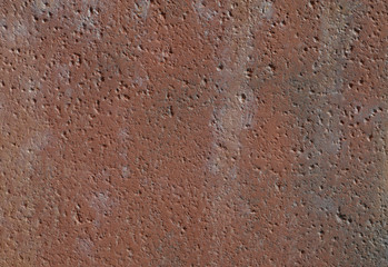 A rough orange red stained concrete surface.
