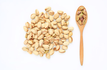 Pistachio nuts isolated on white background with wooden spoon. Top view.