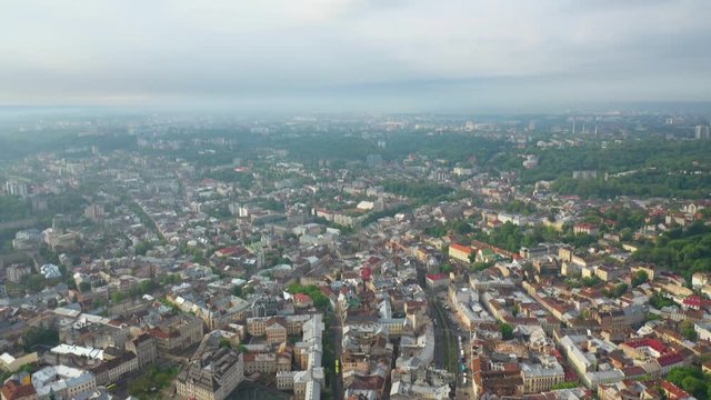 Flying near the town hall in the city of Lviv with rainy weather with clouds