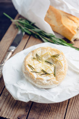 Baked camembert cheese with toasts and rosemary herbs on the rustc background. Selective focus. Shallow depth of field.