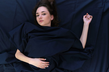 I do not understand what is going on. Concept art photo of body part of the arms and legs of a female brunette girl against a dark background with flowing hair.